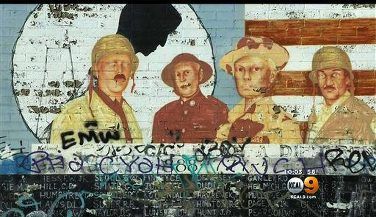 This Friday, May 27, 2016 image from video provided by KCBS-TV/KCAL-TV shows graffiti on a Vietnam War memorial in the Venice area of Los Angeles. The homespun memorial painted on a block-long wall on Pacific Avenue lists the names of American service members missing in action or unaccounted for in Southeast Asia, painted by a Vietnam veteran and dedicated in 1992. The wall has been tagged previously but the latest vandalism - within the past week - covers the bottom half of the memorial for much of its length. (KCBS-TV/KCAL-TV via AP)