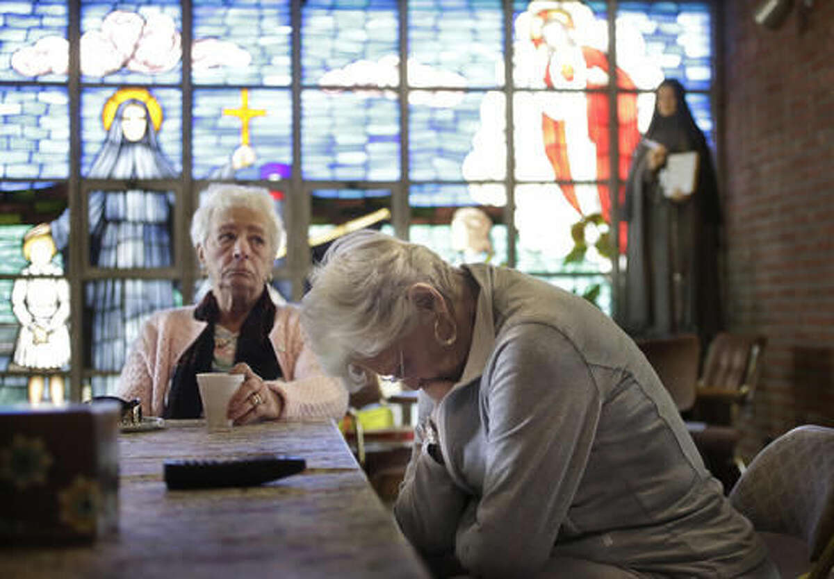 Mary Fernandes, left, and Nancy Shilts, right, and other parishioners at the church of St. Frances X. Cabrini react in the church Monday, May 16, 2016, while talking about its closing in Scituate, Mass. The Supreme Court has refused to hear an appeal from parishioners who are occupying the church, which the Roman Catholic Archdiocese of Boston closed more than a decade ago. (AP Photo/Steven Senne)