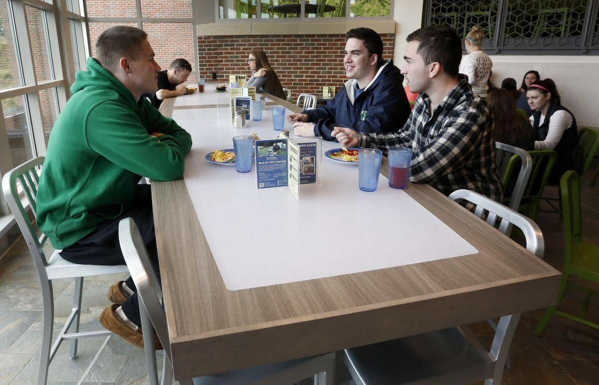 Students at the University of New Hampshire have lunch at the new $17,000 custom-made chef's table at the campus dining hall Friday April 29, 2016 in Durham, N.H. The University of New Hampshire now acknowledges that spending $17,000 on a custom-made chef's table with LED lights for the campus dining hall was a mistake. (AP Photo/Jim Cole)