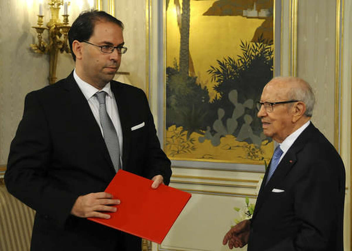 Tunisia's new Prime Minister Youssef Chahed , left, listens to Tunisian President Beji Caid Essebsi at the presidential palace in Tunis, Wednesday, Aug.3, 2016. Chahed served as minister for local affairs in the government that fell over the weekend in a no-confidence vote. The choice of Chahed is controversial in some minds because he is related by marriage to President Beji Caid Essebsi, who nominates the new prime minister. (AP Photo/Hassene Dridi)