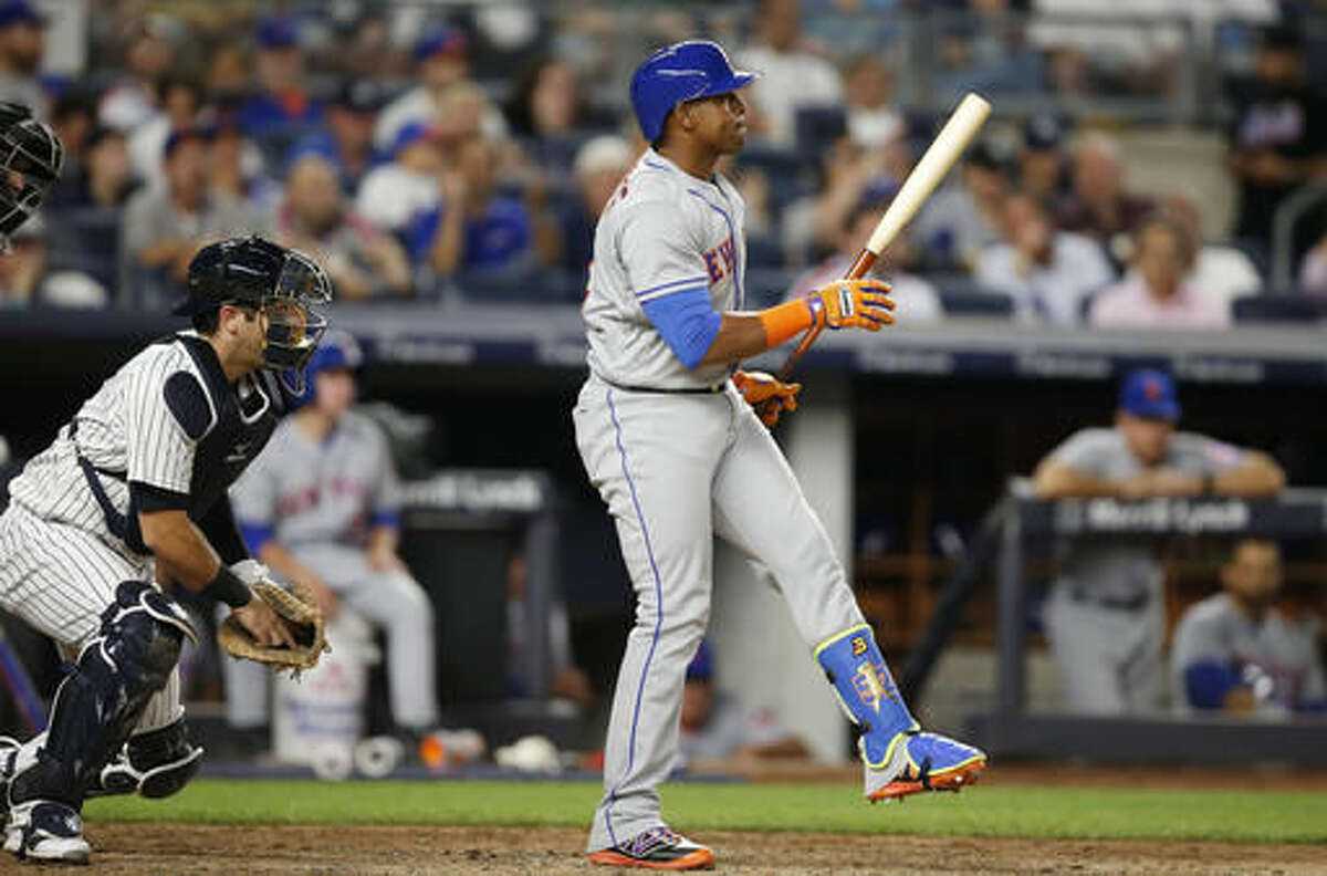 New York Mets' Yoenis Cespedes reacts after striking out swinging with two runners on base, next to New York Yankees catcher Austin Romine during the fourth inning of a baseball game, Wednesday, Aug. 3, 2016, in New York. (AP Photo/Kathy Willens)