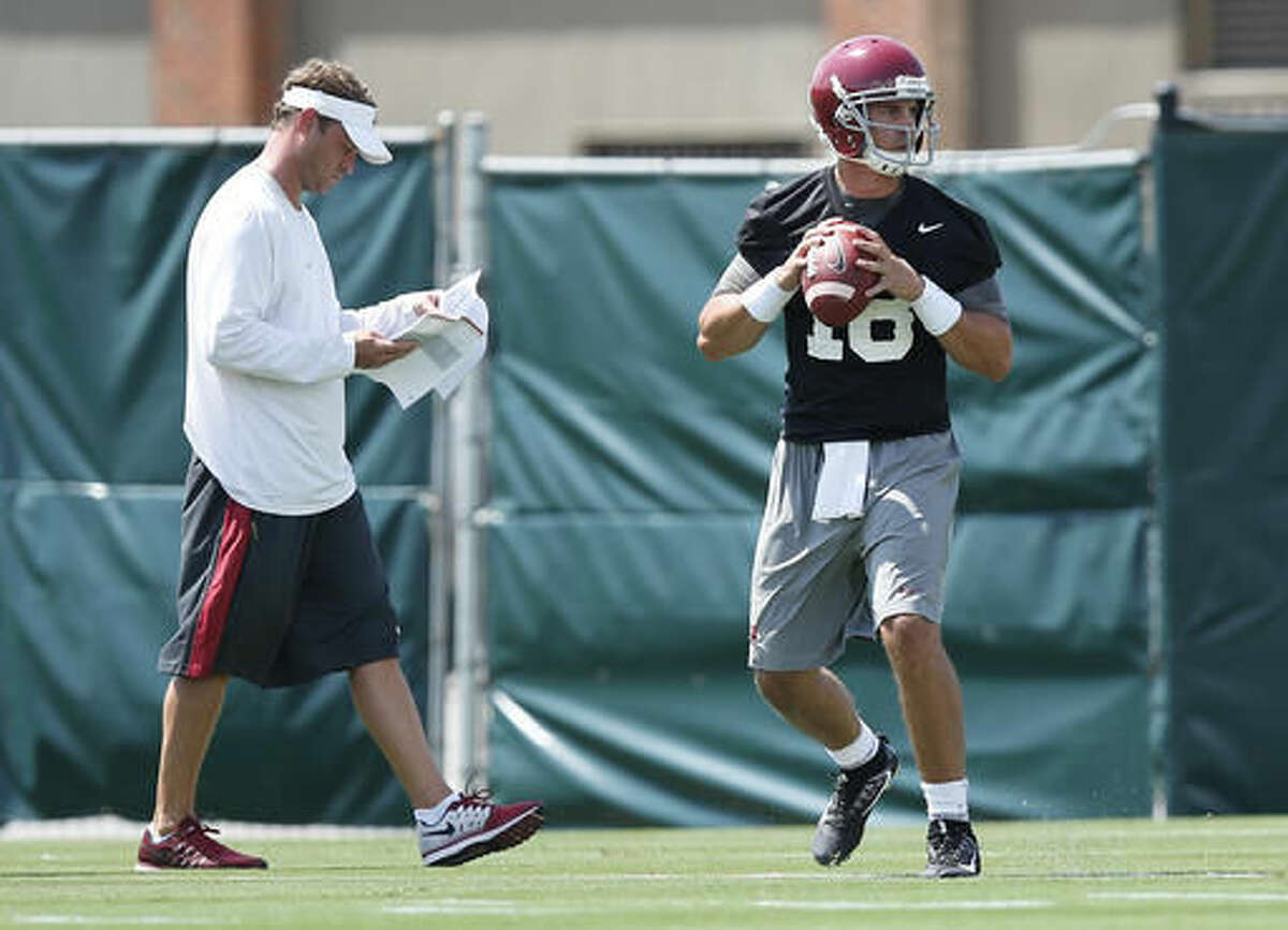Alabama offensive coordinator Lane Kiffin walks behind quarterback Cooper Bateman as he sets back to pass during a drill at an NCAA college football practice, Thursday, Aug. 4, 2016, in Tuscaloosa, Ala. (AP Photo/Brynn Anderson)
