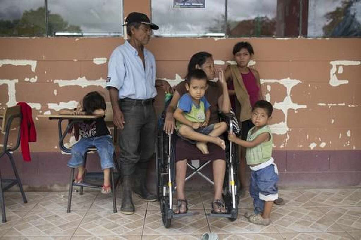 A family sits in a hallway of school turned into temporary shelter for residents seeking refuge from Hurricane Earl in Melchor de Mencos, in the Arroyito neighborhood, in Melchor de Mencos, Guatemala, on the Peten border with Belize, Thursday, Aug. 4, 2016. Earl deteriorated to a weak tropical storm Thursday as it passed over northern Guatemala en route to southern Mexico. (AP Photo/Luis Soto)