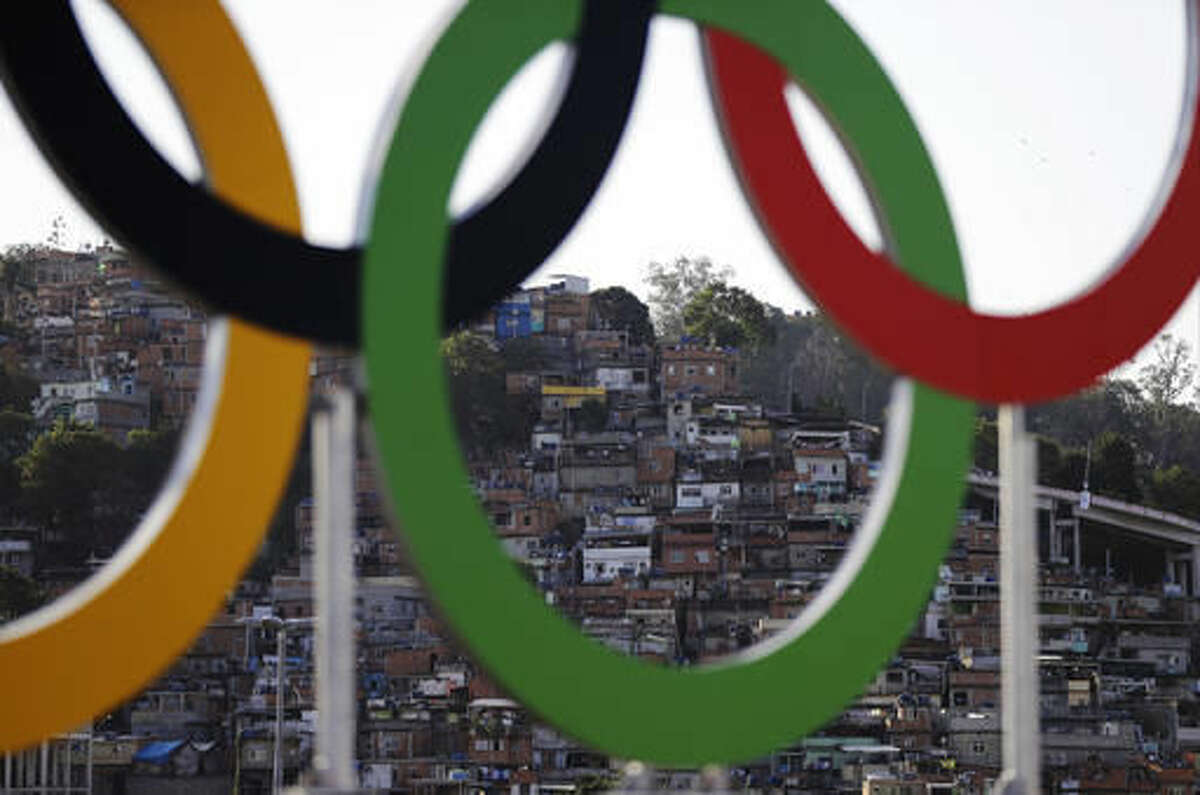 Houses from a favela are photographed through the Olympic rings prior to the opening ceremony for the 2016 Summer Olympics in Rio de Janeiro, Brazil, Friday, Aug. 5, 2016. (AP Photo/Jae C. Hong)