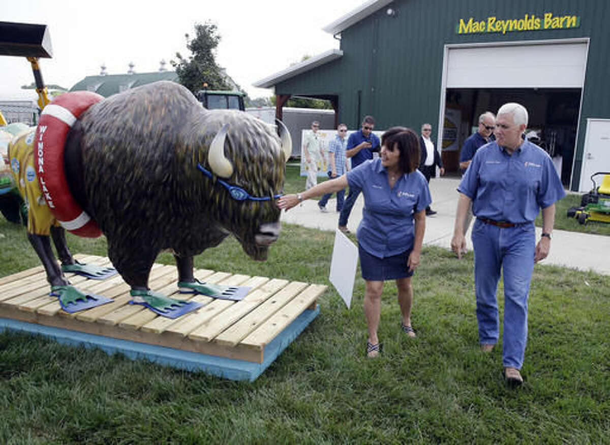 Republican vice presidential candidate, Indiana Gov. Mike Pence and his wife Karen, tour an exhibit of decorated bison for each of Indiana's counties at the Indiana State Fair in Indianapolis, Friday, Aug. 5, 2016. (AP Photo/Michael Conroy)