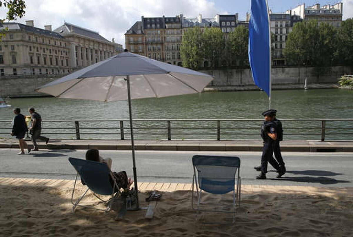 French police officers patrol over the Seine river at Paris Plage (Paris Beach) Friday, Aug. 5, 2016 in Paris. Paris Plage is an artificial beach set up on the right bank of the Seine river with palm trees, outdoor showers and hammocks. Numerous summer festivals have been canceled because maximal security cannot be assured despite additional injection of security forces. (AP Photo/Michel Euler)