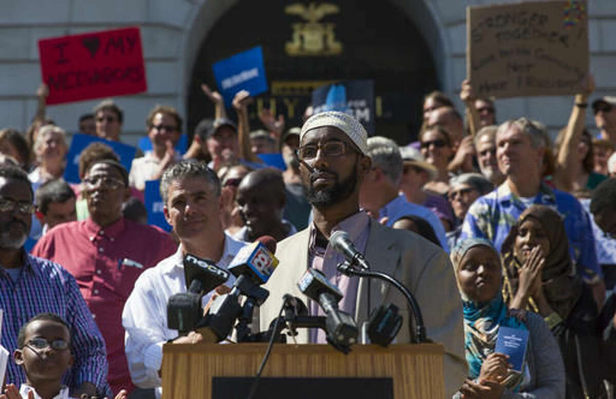 Mahmoud Hassan, president of the Somali Community Center of Maine, pauses for applause during a rally at City Hall to protest comments by Republican presidential candidate Donald Trump, Friday, Aug. 5, 2016 in Portland, Maine, Donald Trump's characterization of Somalis as dangerous and a drag on resources could undo years of work that they have done to establish themselves in the country's whitest state, Somali residents said Friday. (Ben McCanna/Portland Press Herald via AP) MANDATORY CREDIT