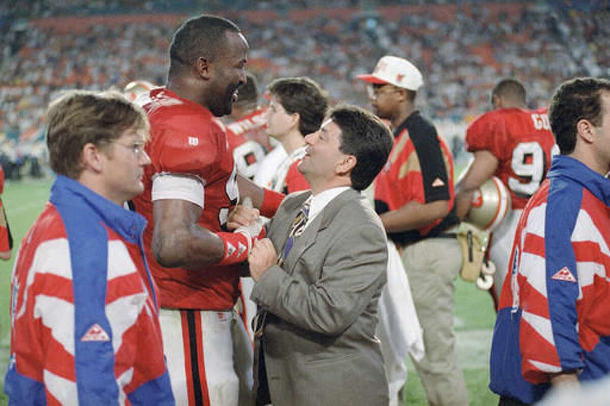 FILE - In this Jan. 29, 1995, file photo, San Francisco 49ers owner Ed DeBartolo Jr. is greeted by 49ers defensive end Tim Harris near the end of Super Bowl XXIX as the 49ers defeated the San Diego Chargers, 49-26, at Joe Robbie Stadium in Miami. DeBartolo will be inducted into the Pro Football Hall of Fame on Saturday, Aug. 6, 2016. (AP Photo/File)