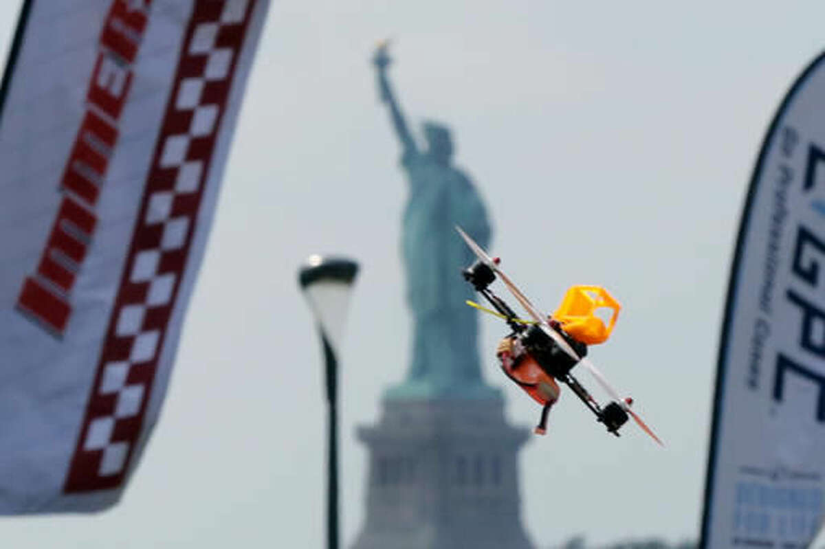A pilot flies a small racing drone through an obstacle course on Governors Island, a former military installation in New York Harbor, Friday, Aug. 5, 2016. Drone pilots are gathering in New York City to compete in the National Drone Racing Championship. (AP Photo/Richard Drew)