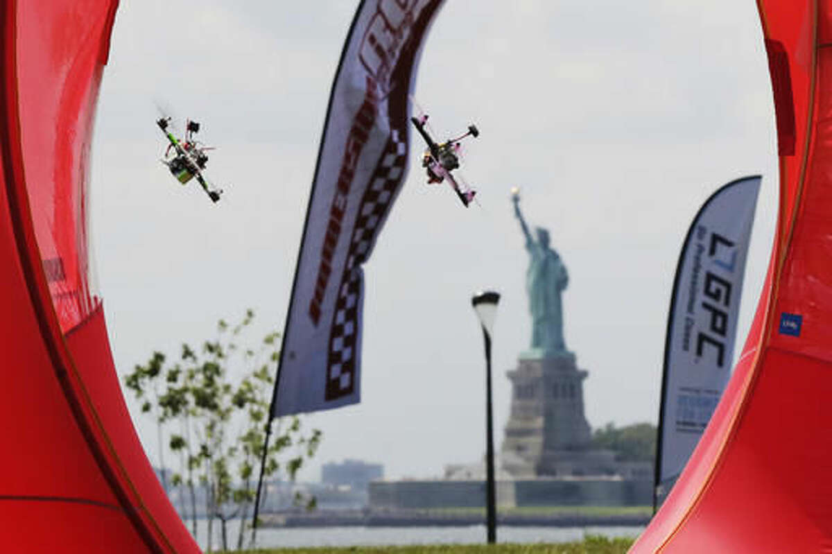Pilots fly their small racing drones through an obstacle course on Governors Island, a former military installation in New York Harbor, Friday, Aug. 5, 2016. Drone pilots are gathering in New York City to compete in the National Drone Racing Championship. (AP Photo/Richard Drew)