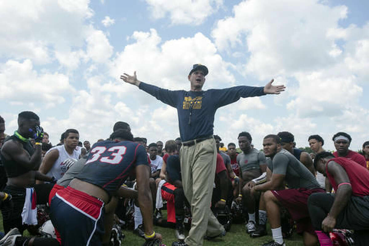 FILE - In this June 5, 2015, file photo, Michigan head coach Jim Harbaugh speaks to participants during the Coach Jim Harbaugh's Elite Summer Football Camp, at Prattville High School in Prattville, Ala. He’s slept at recruit’s houses, had his wife mock his $8 khakis and taken his team on the road for camp, rankling the SEC and forcing the NCAA to take a stand. There may be no louder voice in college football. (Albert Cesare/The Montgomery Advertiser via AP, File)