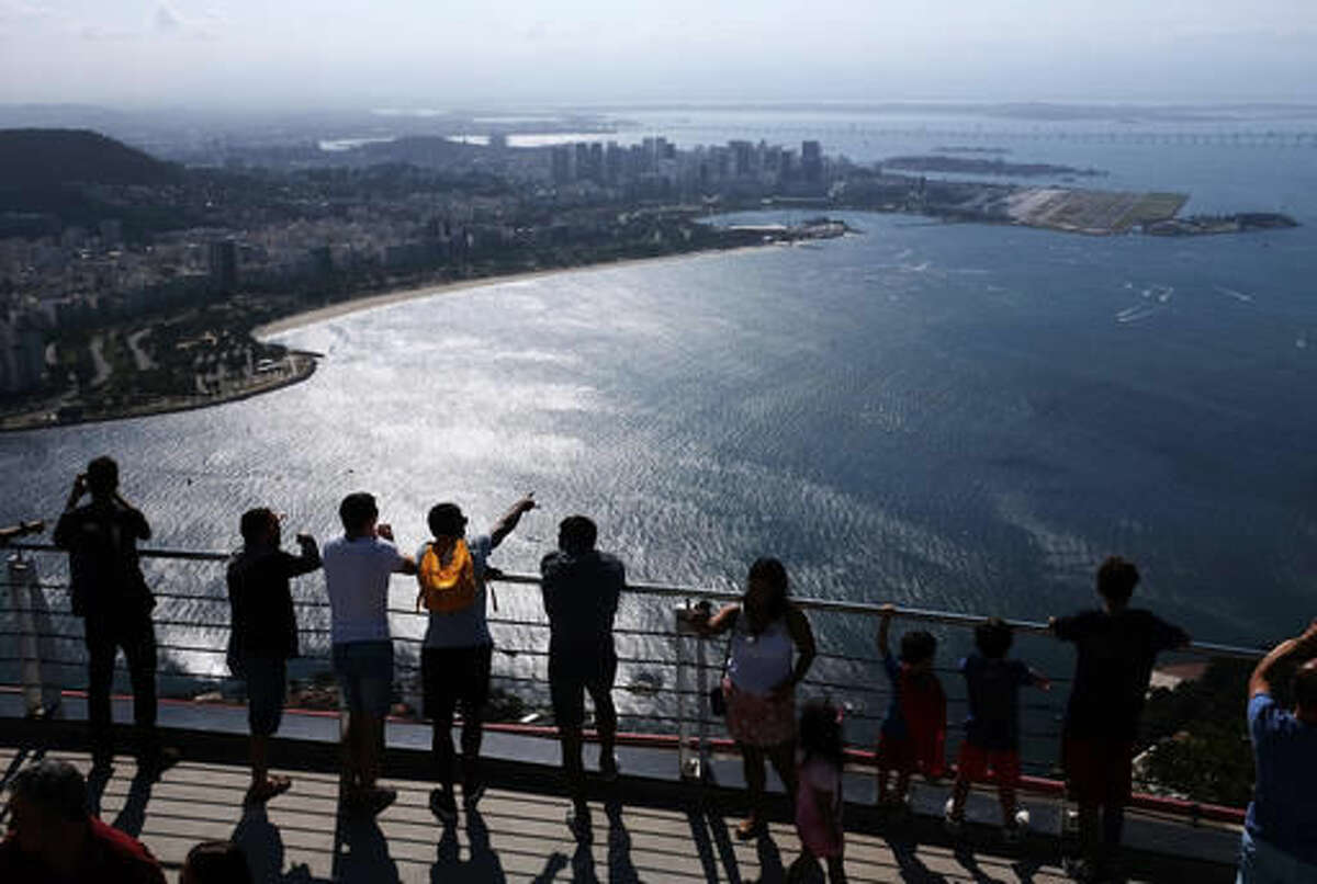 Visitors look out over Guanabara Bay, home of the 2016 Summer Olympics sailing events, as they stand atop Sugarloaf Mountain in Rio de Janeiro, Brazil, Thursday, Aug. 4, 2016. (AP Photo/David Goldman)