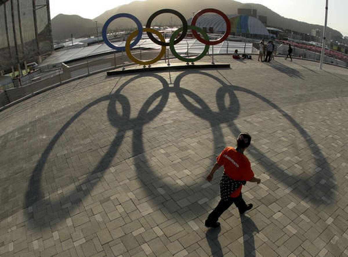 A worker walks past a set of Olympic rings in the Olympic Park ahead of the Rio 2016 Summer Olympics, in Rio de Janeiro, Brazil, Thursday, Aug. 4, 2016. (AP Photo/Charlie Riedel)