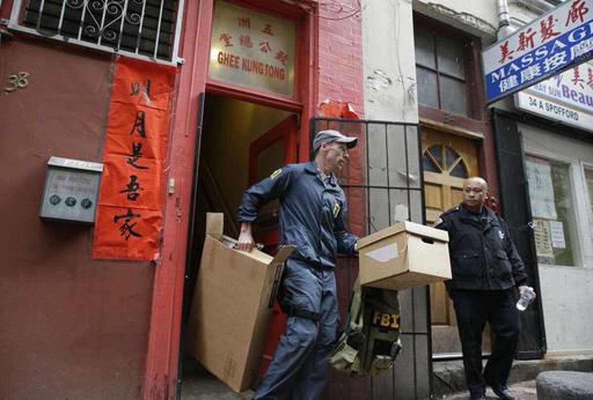 FILE - In this March 26, 2014 file photo, an FBI agent carries out boxes of evidence following a search of a Chinatown fraternal organization in San Francisco. Raymond Chow, a one-time gang tough nicknamed "Shrimp Boy" who insisted he had changed his ways but was hounded by federal investigators is set to be sentenced to life in prison following his conviction on racketeering, murder and scores of other charges. U.S. District Court Judge Charles Breyer is scheduled to sentence Chow on Thursday, Aug. 4, 2016. (AP Photo/Eric Risberg, File)