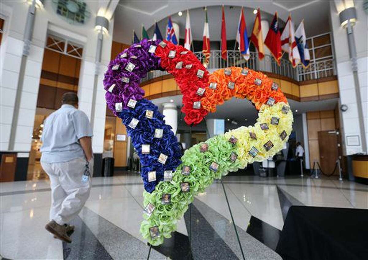 A heart-shaped wreath bears the 49 photos of the victims from the Pulse nightclub massacre, in the atrium of Orlando City Hall, Thursday, Aug. 4, 2016. The wreath was placed at city hall to raise continued awareness for the OneOrlando fund, to benefit the victims of the shootings and their families. (Joe Burbank/Orlando Sentinel via AP)