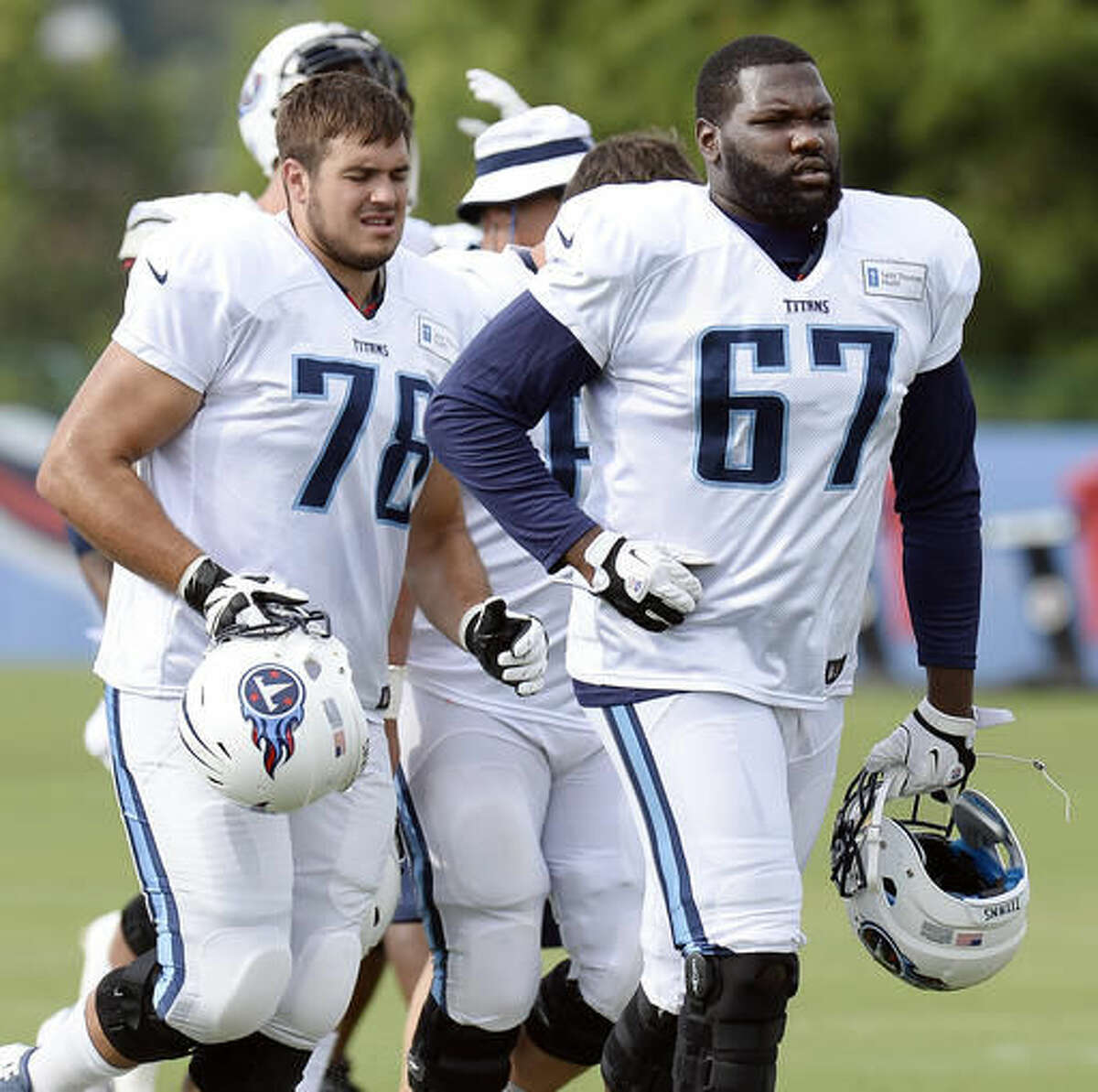 Tennessee Titans offensive tackle Jack Conklin (78) and offensive guard Quinton Spain (67) run off the field after a drill during NFL football training camp Thursday, Aug. 4, 2016, in Nashville, Tenn. (AP Photo/Mark Zaleski)