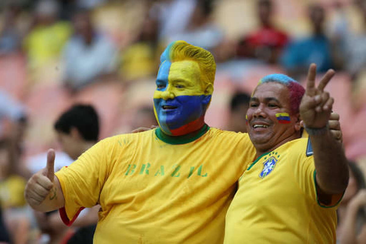 Fans of Colombia and Sweden pose for a photo during a group B match of the men's Olympic football tournament between Sweden and Colombia at the Amazonia Arena, in Manaus, Brazil, Thursday, Aug. 4, 2016. (AP Photo/Michael Dantas)