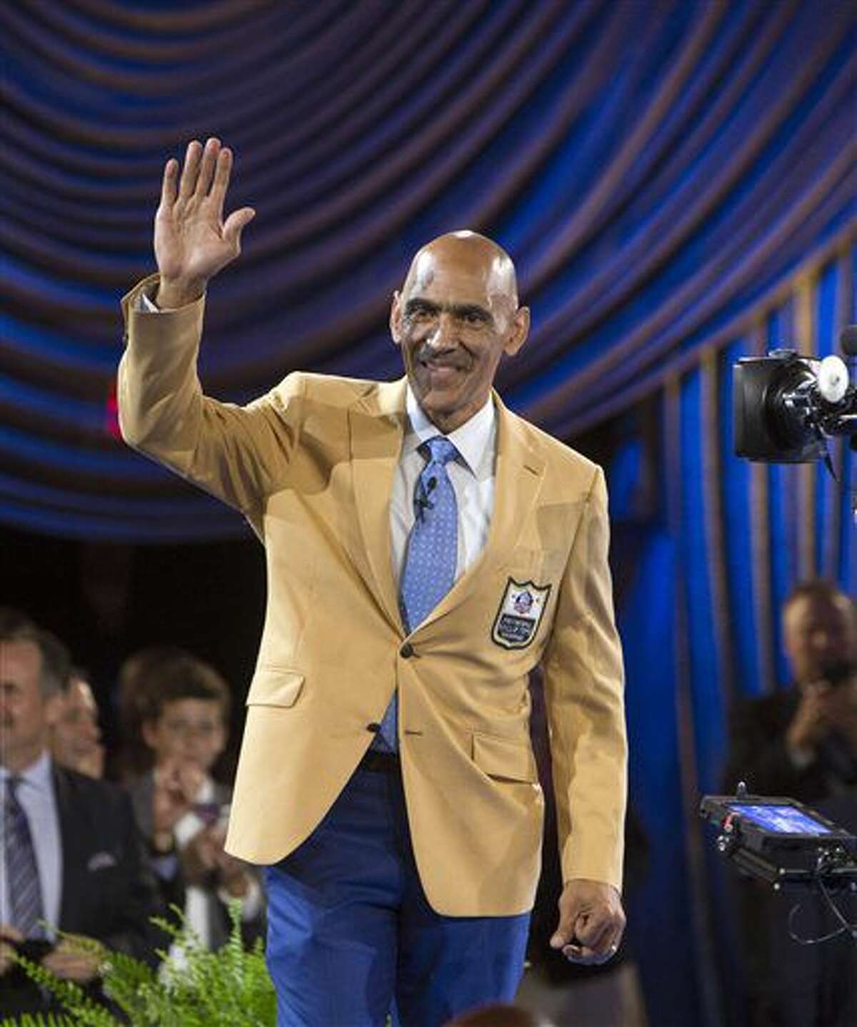 Tony Dungy waves after he received his gold jacket at the Pro Football Hall of Fame enshrinees' dinner, Thursday, Aug. 4, 2016, in Canton, Ohio. (Scott Heckel/The Repository via AP)