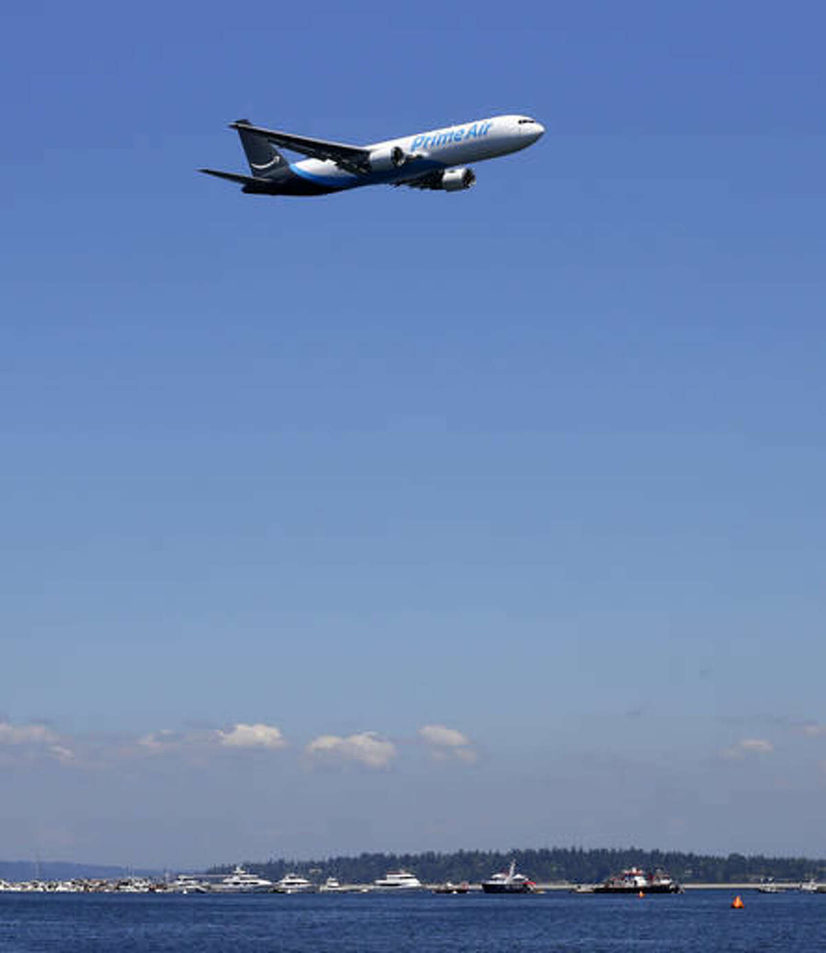 A Boeing 767 with an Amazon.com "Prime Air" livery flies over Lake Washington, Friday, Aug. 5, 2016, as part of the Boeing Seafair Air Show. Amazon unveiled its first branded cargo plane Thursday, one of 40 freighters that will make up the company's own air transportation network of 40 Boeing jets leased from Atlas Air and Air Transportation Services Group, which will operate the air cargo network. (AP Photo/Ted S. Warren)