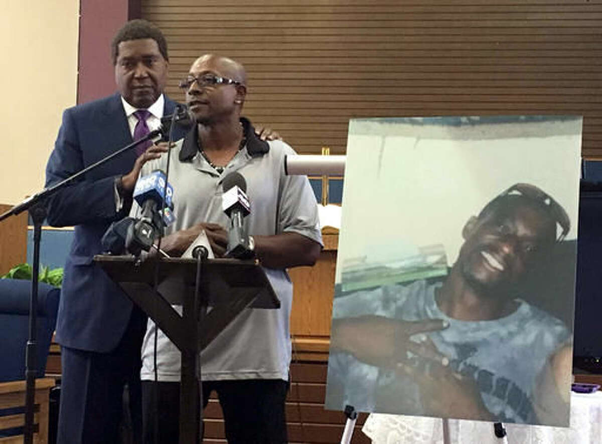 Robert Mann Sr., right, addresses community members and reporters Friday, Aug. 5, 2016, at Allen Chapel AME Church in Sacramento, Calif., accompanied by attorney John Burris. Displayed at right is a photo of Mann’s brother, Joseph, who was shot and killed by Sacramento police last month. (AP photo/Darcy Costello)