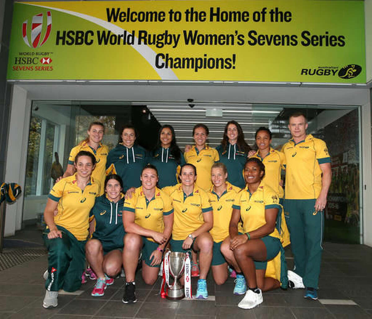 In this June 1, 2016, photo the Australian women's rugby sevens team, including Ellia Green in the front row at right, pose with their World champions trophy in Sydney. The so-called fastest woman in world rugby, for a long time Green trained in track and field and competed at international level for Australia before making a sudden move into a rough-and-tumble sport that is making its Olympic debut in Rio de Janeiro. (AP Photo/Rick Rycroft)