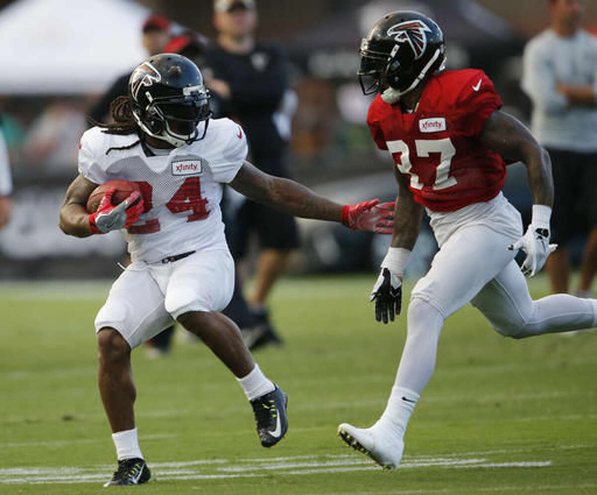 Atlanta Falcons running back Devonta Freeman (24) tries to break way from free safety Ricardo Allen (37) during the NFL football team's annual Friday Night Lights practice, at Grayson High School on Friday, Aug. 5, 2016, in Loganville, Ga. (AP Photo/John Bazemore)