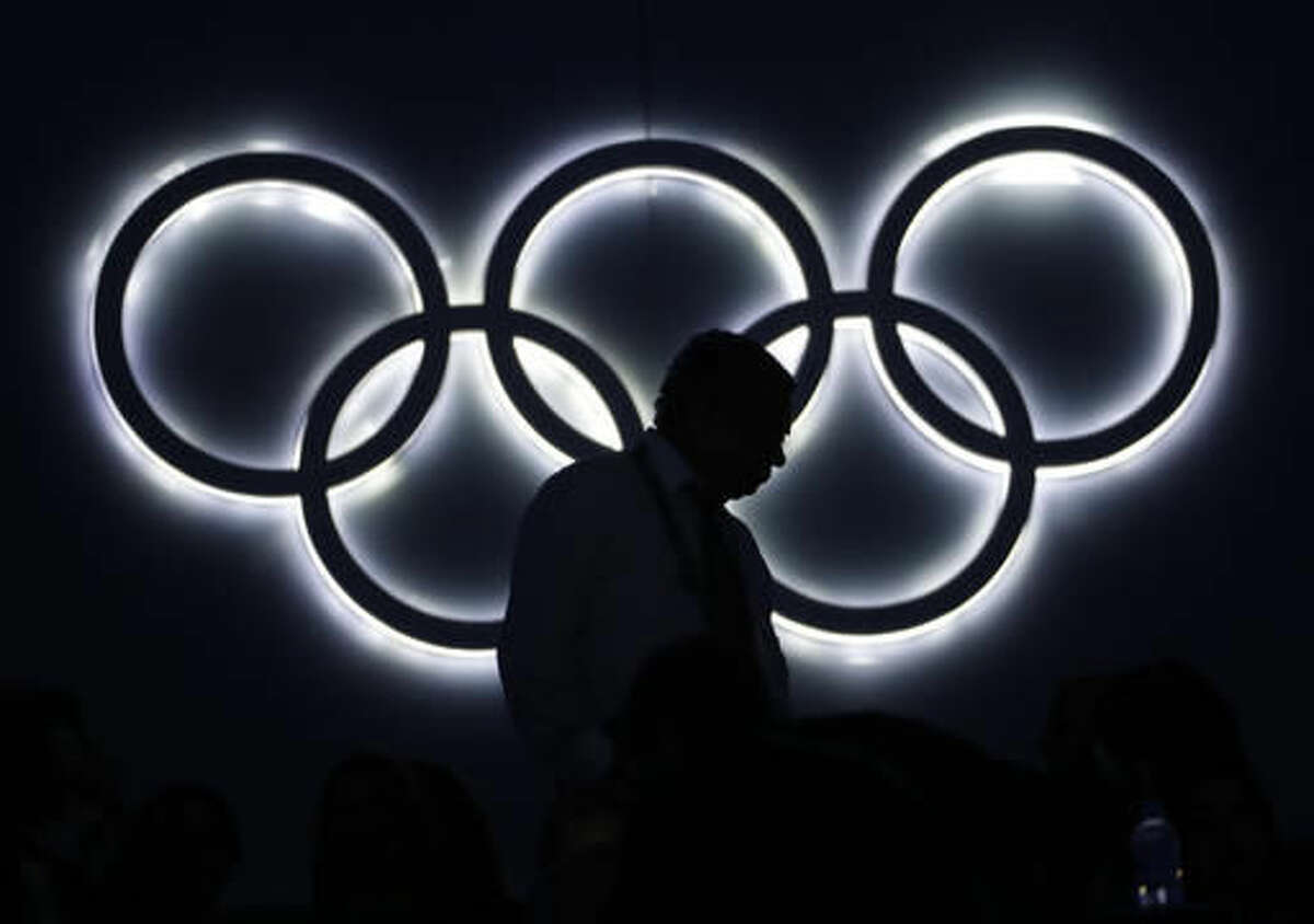 A spectator walks to his seat, past an illuminated Olympic rings during the opening ceremony for the 2016 Summer Olympics in Rio de Janeiro, Brazil, Friday, Aug. 5, 2016. (AP Photo/David Goldman)