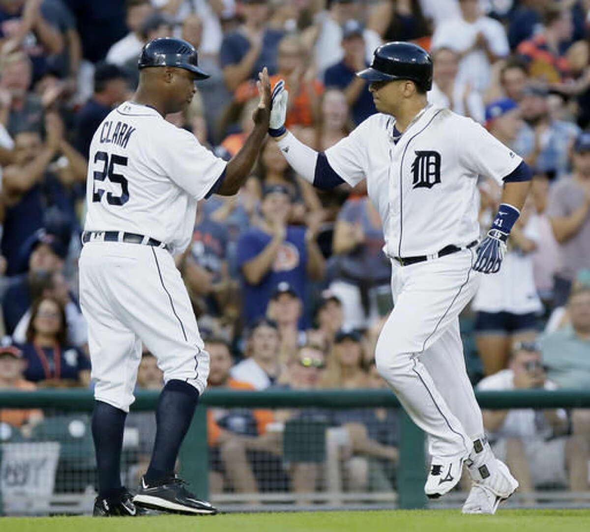 Detroit Tigers' Victor Martinez receives a high-five from third base coach Dave Clark (25) after hitting a two-run home run against the New York Mets during the fourth inning of an interleague baseball game Friday, Aug. 5, 2016, in Detroit. (AP Photo/Duane Burleson)