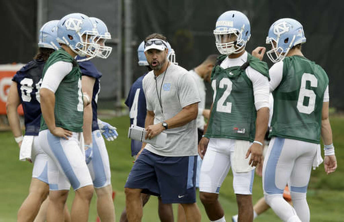 North Carolina coach Larry Fedora directs his players during the team's first NCAA college football practice of the season in Chapel Hill, N.C., Friday, Aug. 5, 2016. (AP Photo/Gerry Broome)