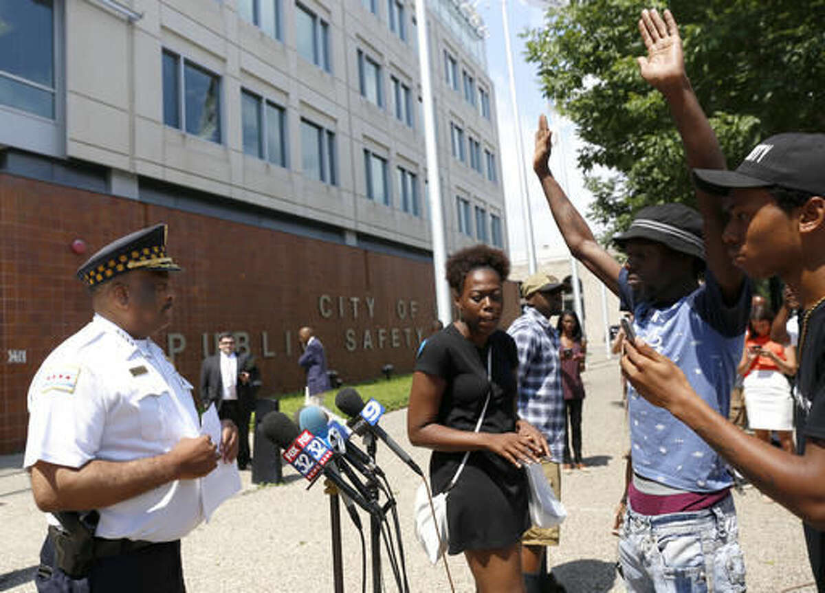 Chicago Police Superintendent Eddie Johnson, left, is blocked by three protestors as he tries to deliver a written statement about the recent release of police shooting video to television reporters outside the police department headquarters Friday, Aug. 5, 2016, in Chicago. (AP Photo/Tae-Gyun Kim)