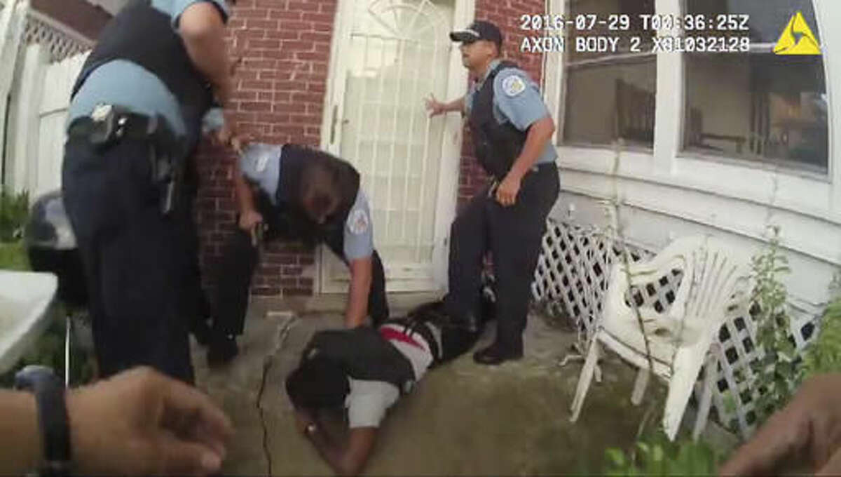 In this frame grab from a body cam provided by the Independent Police Review Authority, Chicago police officers handcuff Paul O'Neal, suspected of stealing a car, after they fired into the vehicle he was driving and then pursued him through a yard on July 28, 2016, in Chicago. The video released Friday, Aug. 5, 2016, was the city's first release of video of the fatal police shooting under a new Chicago policy that calls for such images to be made public within 60 days. (Chicago Police Department/Independent Police Review Authority via AP)