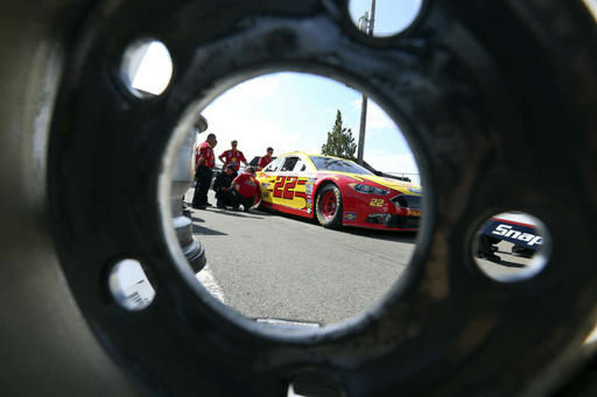The race car of Joey Logano (22) is seen through a race wheel in the garage area at Watkins Glen International racetrack during practice for Sunday's NASCAR Sprint Cup Series auto race Friday, Aug. 5, 2016, in Watkins Glen, N.Y. (AP Photo/Mel Evans)