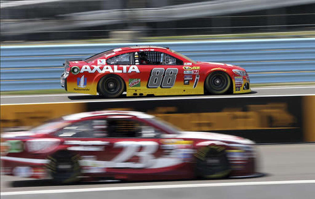 Jeff Gordon (88) drives past the pits and David Ragan (23) at Watkins Glen International racetrack during practice for Sunday's NASCAR Sprint Cup Series auto race Friday, Aug. 5, 2016, in Watkins Glen, N.Y. Gordon came out of retirement to fill in for the injured Dale Earnhardt Jr. (AP Photo/Mel Evans)