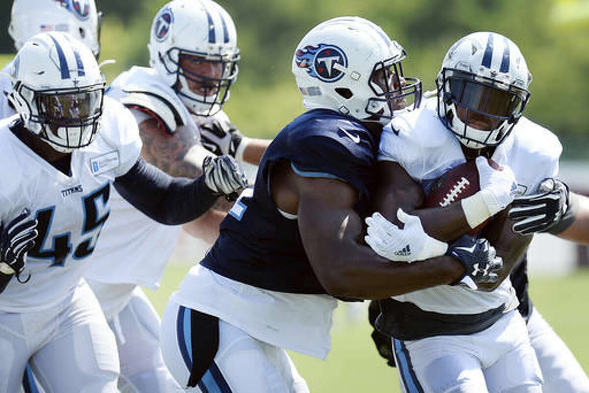 Tennessee Titans outside linebacker David Bass, center, stops running back DeMarco Murray, right, after a play during NFL football training camp Friday, Aug. 5, 2016, in Nashville, Tenn. (AP Photo/Mark Zaleski)