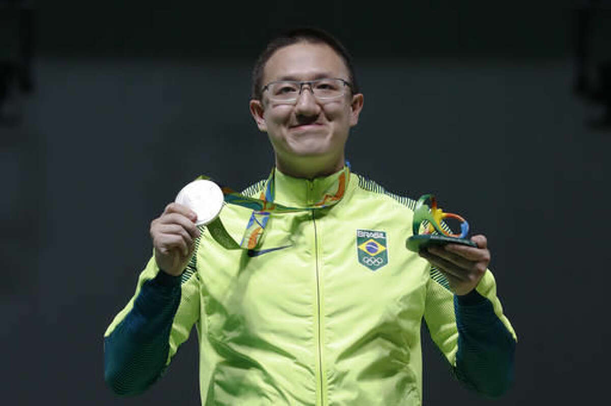 Felipe Wu of Brazil poses for photographers with his silver medal during the award ceremony of the men's 10-meter air pistol event at Olympic Shooting Center at the 2016 Summer Olympics in Rio de Janeiro, Brazil, Saturday, Aug. 6, 2016. (AP Photo/Hassan Ammar)