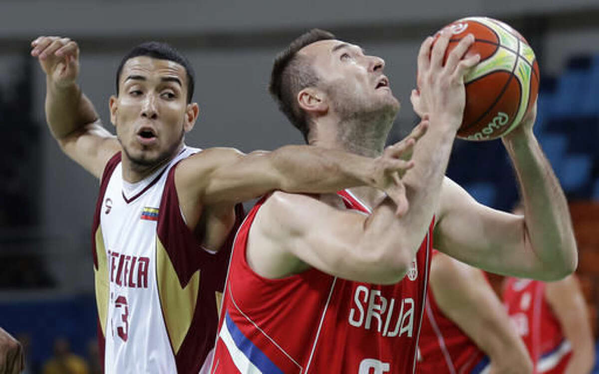 Serbia's Milan Macvan is fouled by Venezuela's Anthony Perez, left, while driving to the basket during a basketball game at the 2016 Summer Olympics in Rio de Janeiro, Brazil, Saturday, Aug. 6, 2016. (AP Photo/Charlie Neibergall)