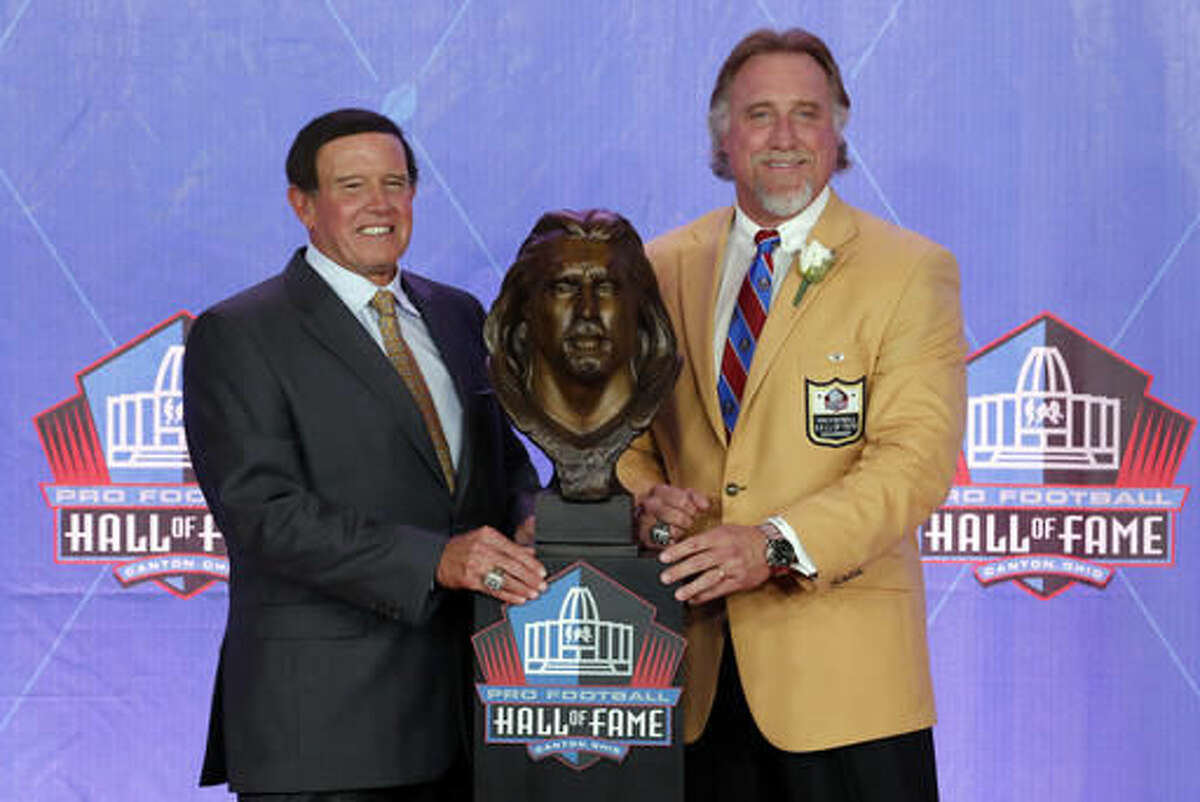 Former NFL player Kevin Greene, right, and his former coach Dom Capers pose with his bust during an induction ceremony at the Pro Football Hall of Fame, Saturday, Aug. 6, 2016, in Canton, Ohio. (AP Photo/Gene J. Puskar)