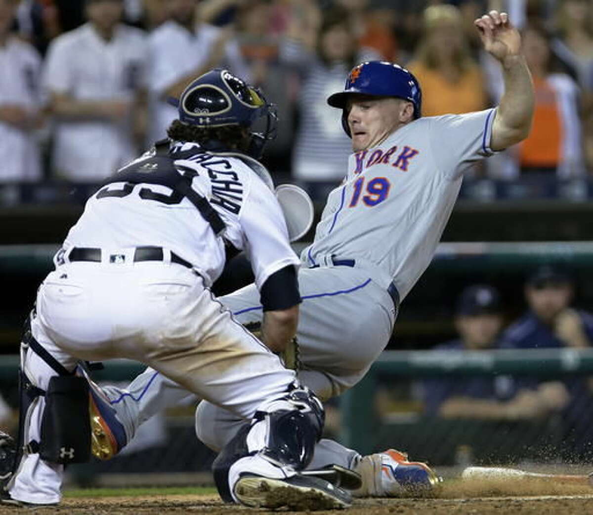 New York Mets' Jay Bruce (19) slides into the tag from Detroit Tigers catcher Jarrod Saltalamacchia while trying to score from second base during the ninth inning of an interleague baseball game Saturday, Aug. 6, 2016, in Detroit. The Tigers defeated the Mets 6-5. (AP Photo/Duane Burleson)