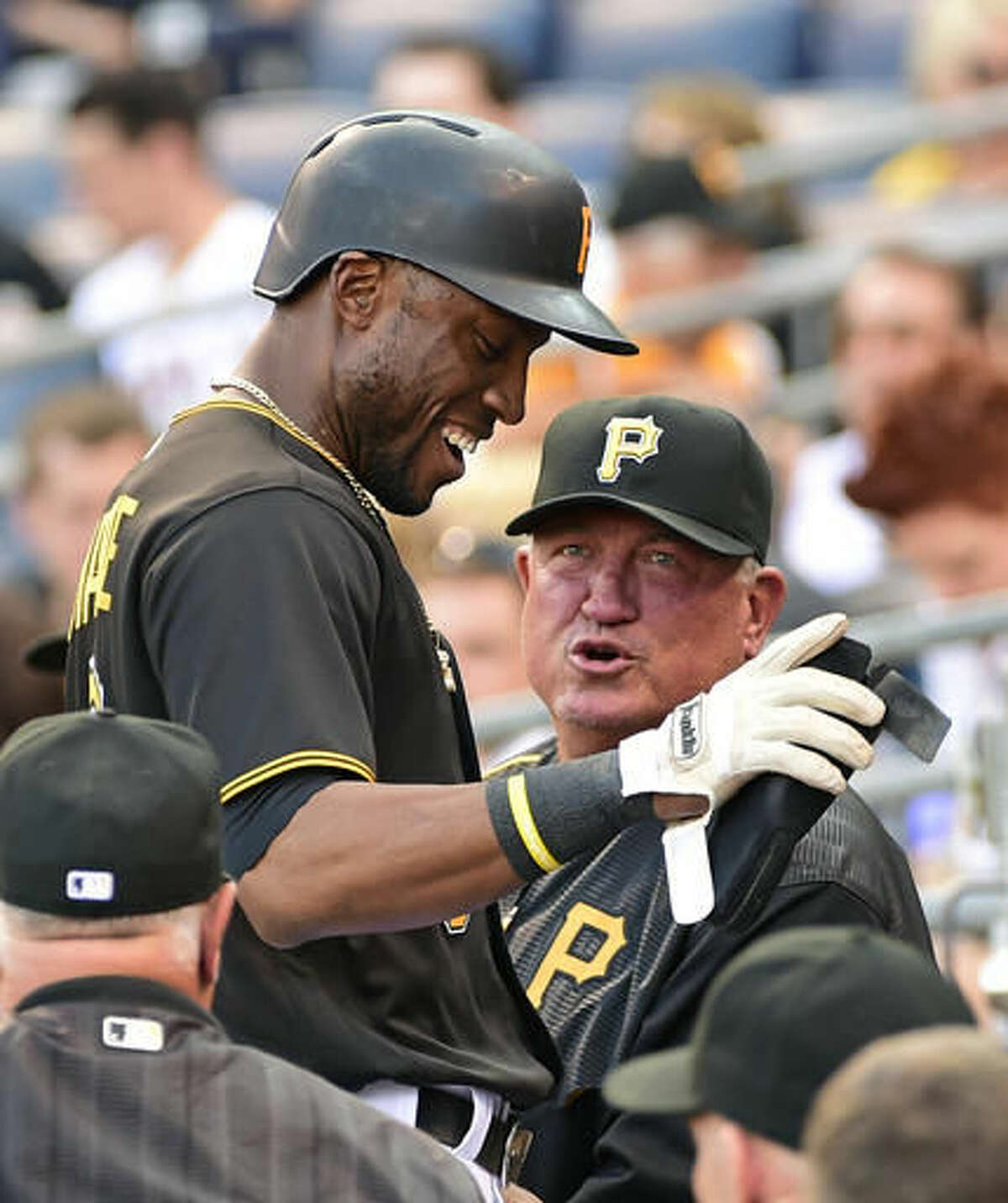 Pittsburgh Pirates Starling Marte (6), left, is congratulated by manager Clint Hurdle (13) after scoring in the first inning of a baseball game against the Cincinnati Reds in Pittsburgh, Saturday, Aug. 6, 2016. (AP Photo/Fred Vuich)