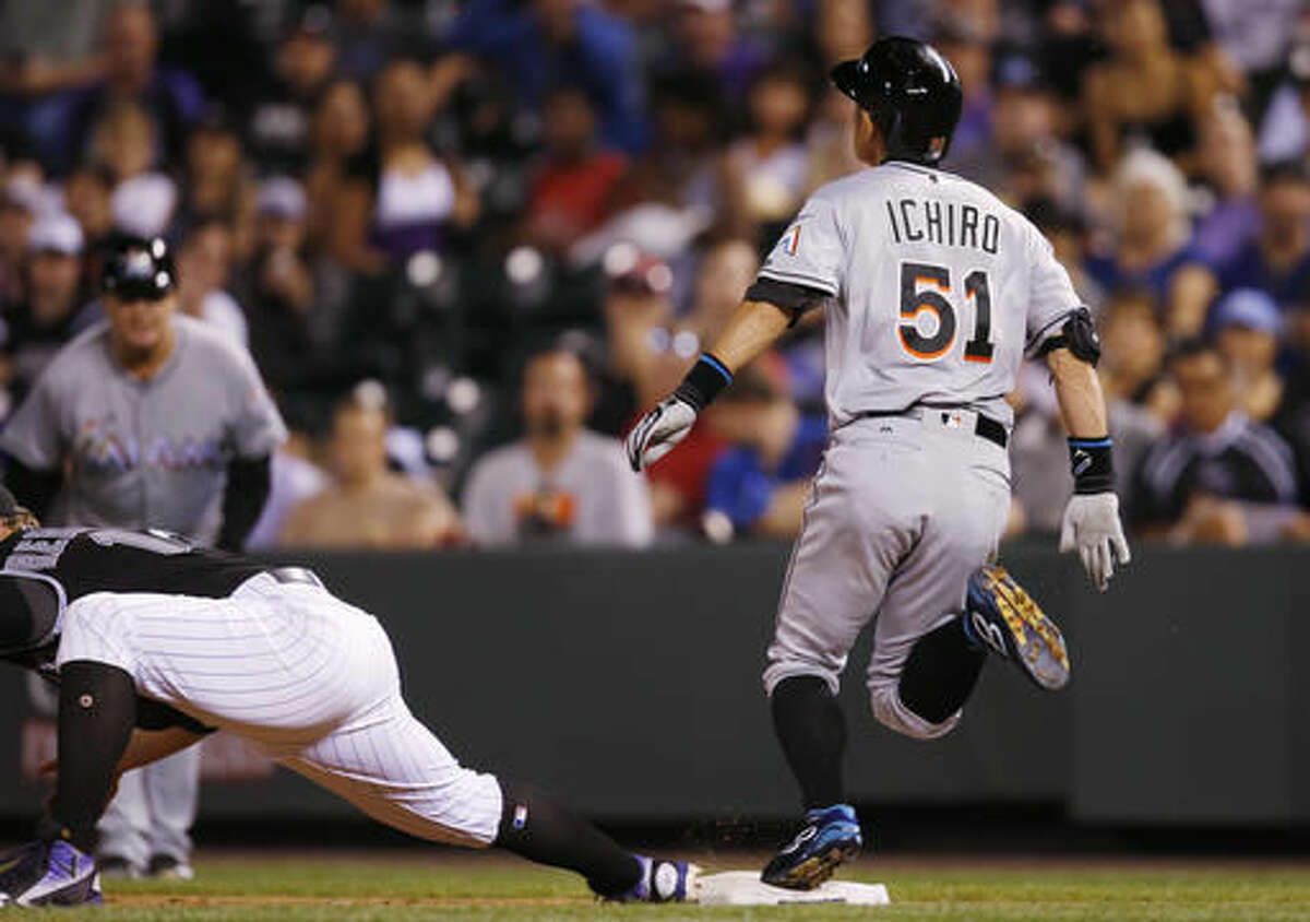 Miami Marlins pinch-hitter Ichiro Suzuki, right, beats the throw to Colorado Rockies first baseman Mark Reynolds for an infield single in the eighth inning of a baseball game Saturday, Aug. 6, 2016, in Denver. The hit was the 2,999th in Suzuki's carer in the Major League. (AP Photo/David Zalubowski)