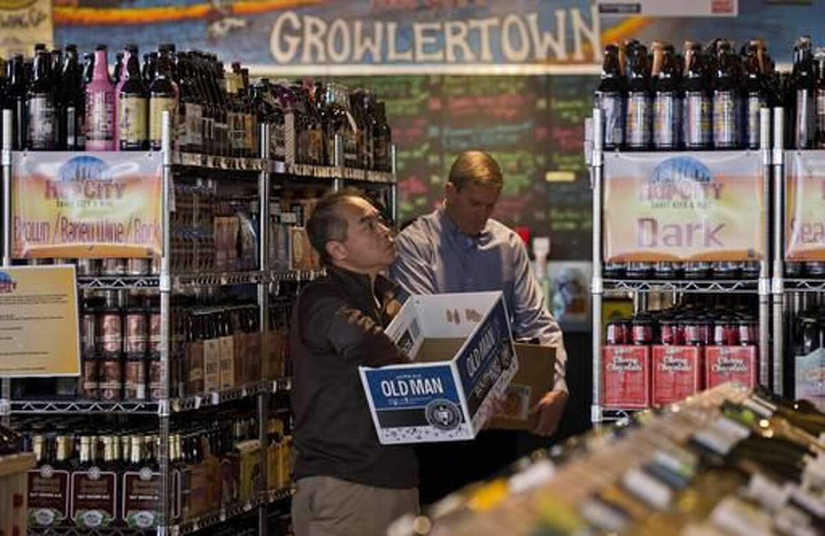 In this photo taken Wednesday, Dec. 11, 2013, shoppers search for their favorite beers at Hop City Craft Beer and Wine in Birmingham, Ala. Alabama's alcohol regulators want the name, address, age and phone number of everyone who buys beer in one of the state's craft breweries and takes it home to drink, a move that is raising concerns about privacy. he Alabama Alcoholic Beverage Control Board is considering a new rule that would require brewers to collect the personal information of anyone who purchases beer at a brewery for off-premise consumption. (AP Photo/Dave Martin)