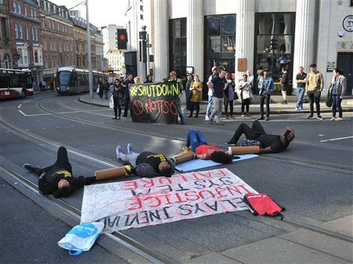 Activistas bliquean una calle en las afueras del Nottingham Theatre Royal en el centro de Nottingham, Inglaterra, como parte de una serie de protestas del movimiento Black LIves Matter en Gran Bretaña el viernes, 5 de agosto del 2016. (Edward Smith/PA via AP)