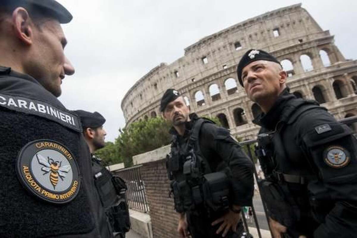 Carabinieri (Italian paramilitary police) special unit's officers patrol the area next to the Colosseum, visible in background, in Rome, Friday, Aug. 5, 2016. Anti-terrorism measures have been tightened in Rome. They include the stationing of police cars and van at the end of a boulevard that runs past the Colosseum, and police patrols and surveillance along Via del Corso, a long street lined with clothing shops and which also runs by the premier’s office. (Claudio Peri/ANSA via AP)