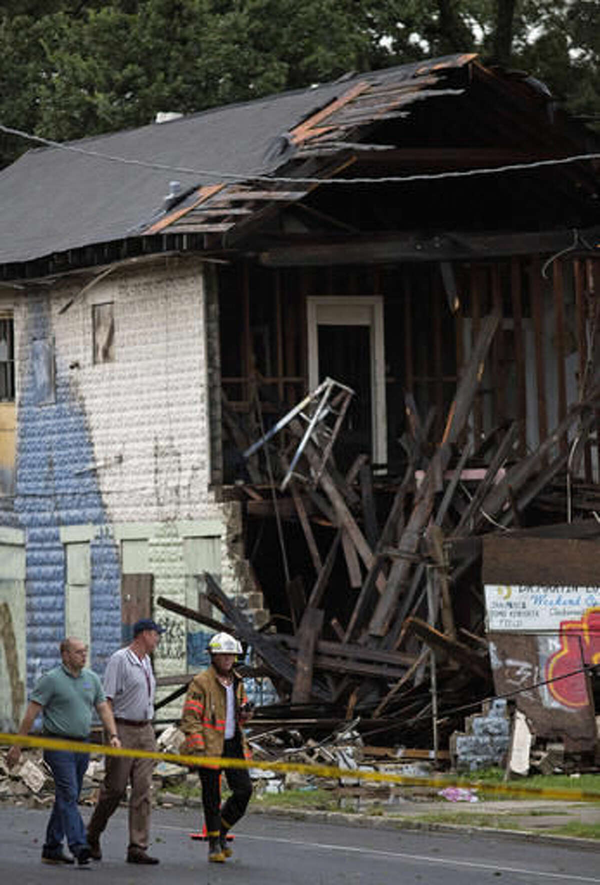 Emergency responders inspect a partially collapsed building on the corner of North Claiborne Avenue and Ursulines Avenue after heavy rains and powerful winds hit New Orleans on Thursday, Aug. 4, 2016. A brief but intense storm pummeled New Orleans on Thursday afternoon, toppling trees and power lines and collapsing at least two abandoned houses. (AP Photo/Max Becherer)