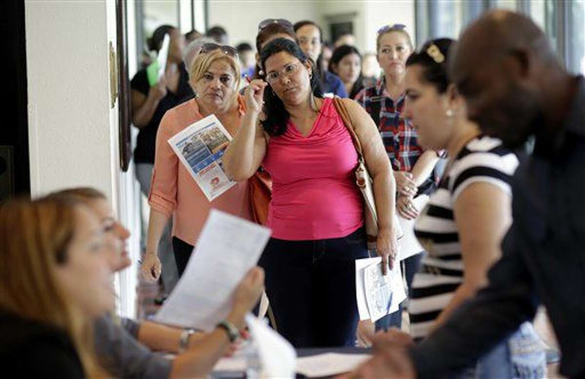 En esta foto del 19 de julio de 2016, Reina Borges, izquierda, presenta solicitud de empleo en una feria laboral en Miami Lakes, Florida. La economía creó 225.000 empleos en julio y la tasa de desempleo se mantuvo en 4,5%, informó el gobierno el viernes 5 de agosto de 2016. (AP Foto/Lynne Sladky)