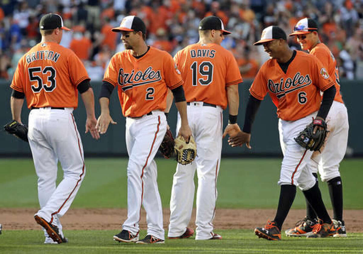 FILE - In this June 18, 2016, file photo, Baltimore Orioles players celebrate after 4-2 win against the Toronto Blue Jays, in Baltimore. Coming off another series win at Camden Yards, this time over the AL West-leading Texas Rangers, the Orioles boast a major-league best 39-17 record at home. From left are Zach Britton, J.J. Hardy, Chris Davis and Jonathan Schoop (6). (AP Photo/Patrick Semansky, File)