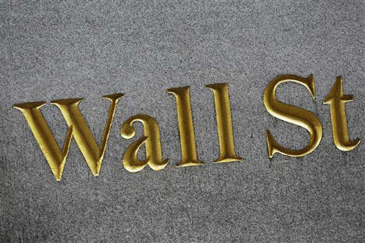 This July 6, 2015 photo shows a sign for Wall Street carved into the side of a building, in New York. Global stocks rose and the British pound fell Thursday, Aug. 4, 2016 after the Bank of England unveiled stimulus measures to help the economy deal with the uncertainty over the vote to leave the European Union. (AP Photo/Mark Lennihan)