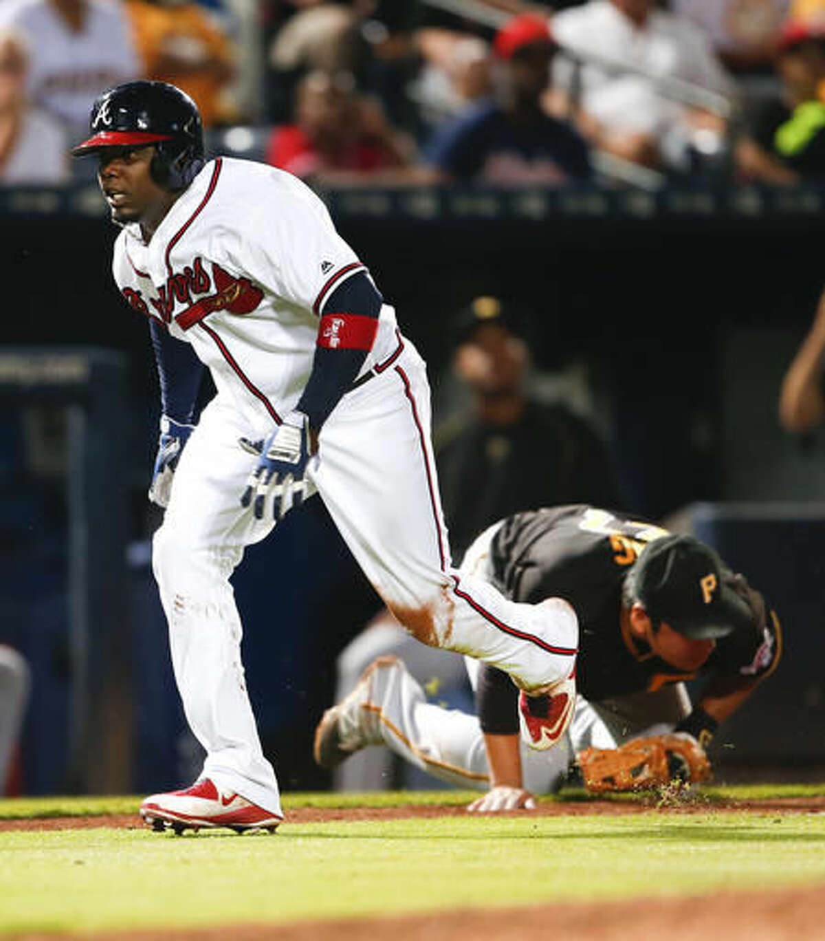 Atlanta Braves' Adonis Garcia races home to score as the ball gets away from Pittsburgh Pirates third baseman Jung Ho Kang after Garcia took third during the seventh inning of a baseball game Thursday, Aug. 4, 2016, in Atlanta. Kang was charged with an error on the play. (AP Photo/John Bazemore)