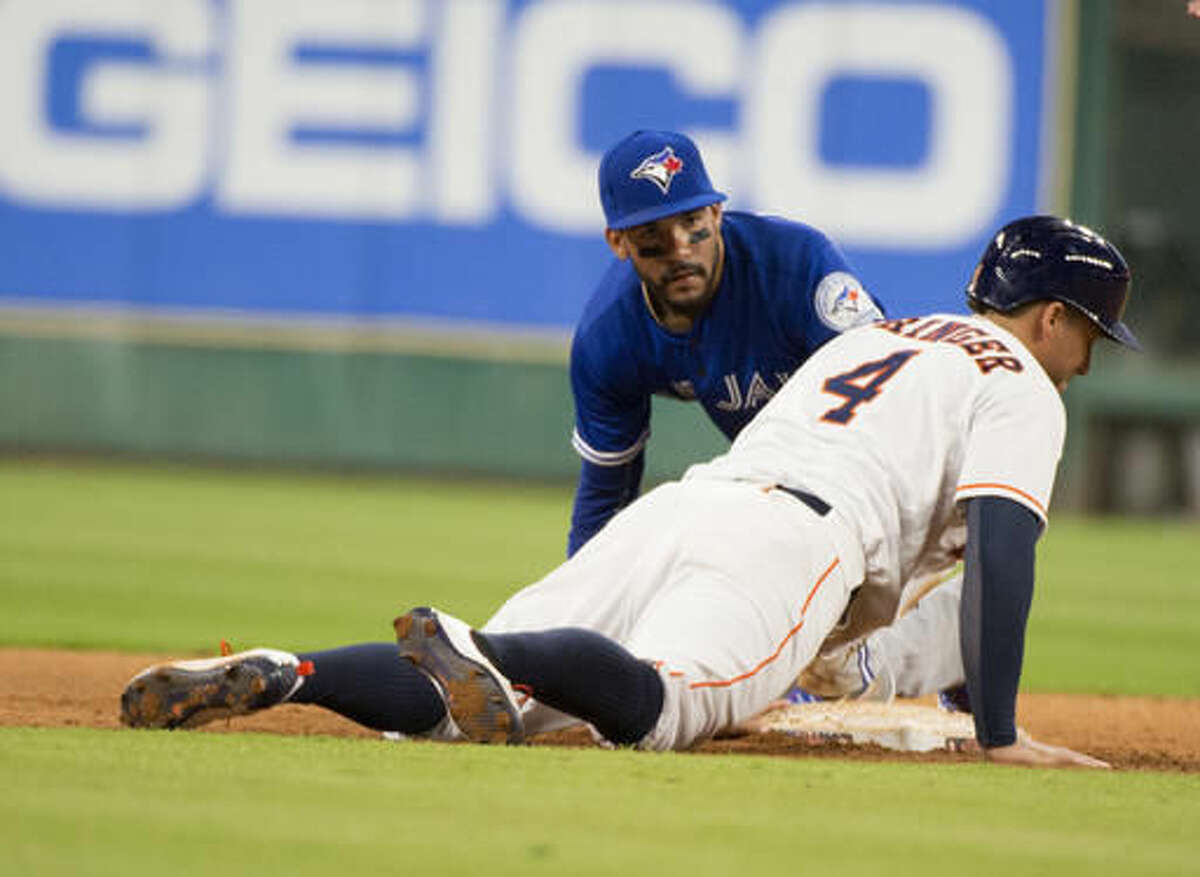 Houston Astros' George Springer (4) slides safely back after rounding second in front of Toronto Blue Jays second baseman Devon Travis during the sixth inning of a baseball game Thursday, Aug. 4, 2016, in Houston. (AP Photo/George Bridges)