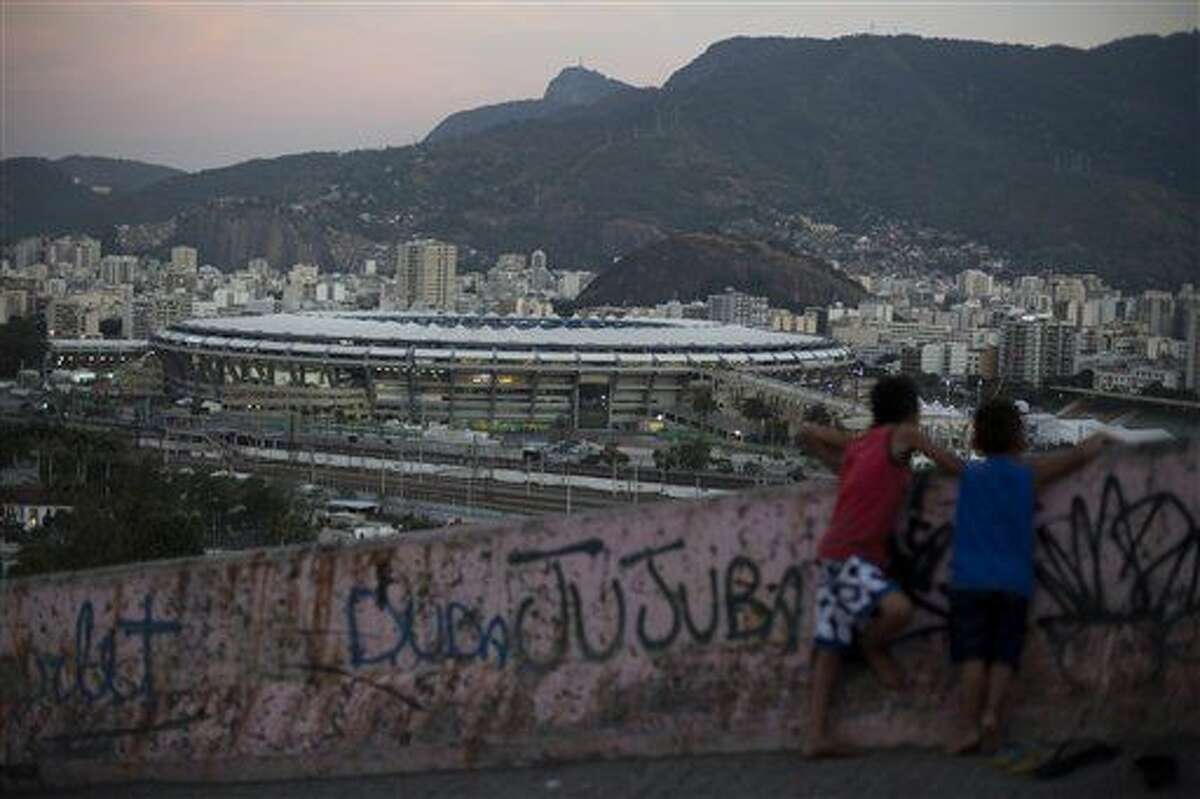 Dos niños miran desde la favela Mangueira hacia el estadio Maracaná antes de la ceremonia inaugural de los Juegos Olímpicos el viernes, 5 de agosto de 2016, en Río de Janeiro. (AP Photo/Leo Correa)